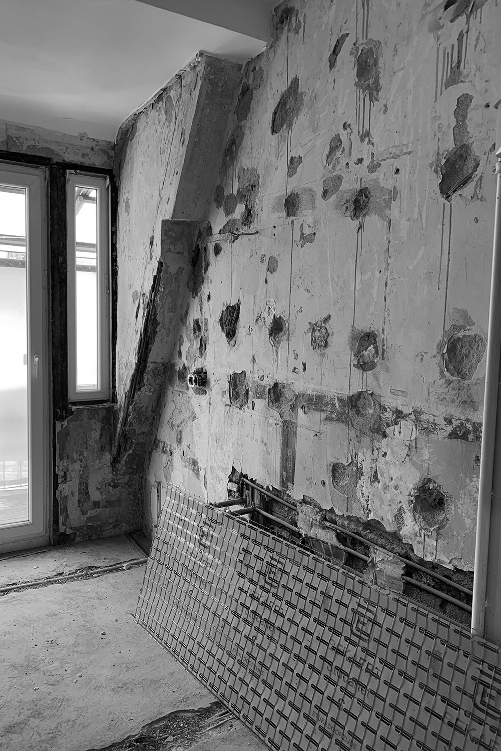 Wände eines im Bau befindlichen Badezimmers mit freiliegenden Balken, die sich in schlechtem Zustand befinden.