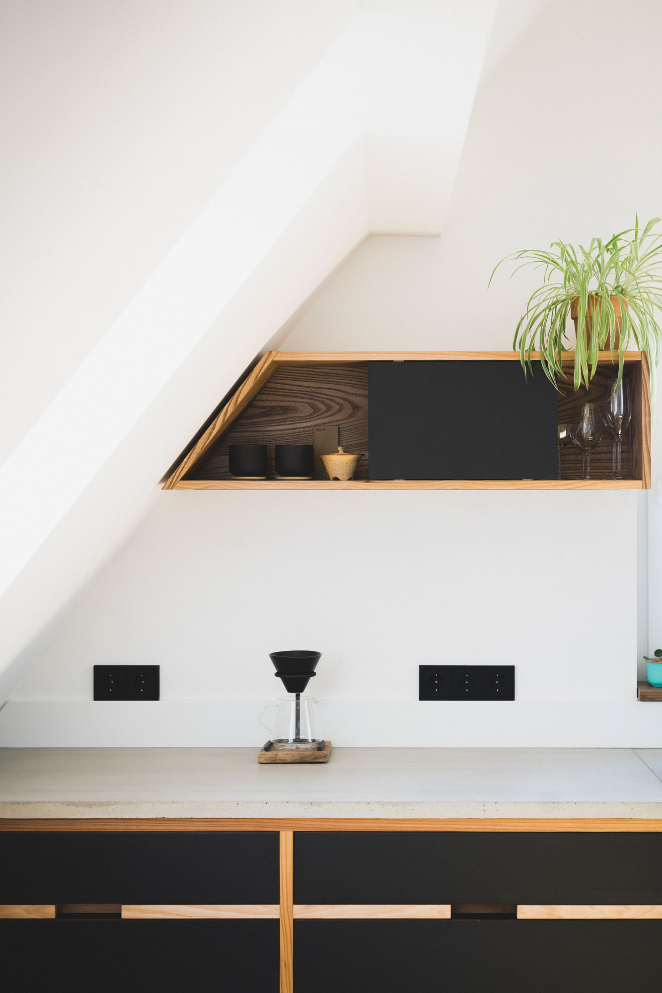 Holzregale mit schwarzer Umrandung mit Designgläsern und Dekoelementen in einer Wohnung in Nürnberg.