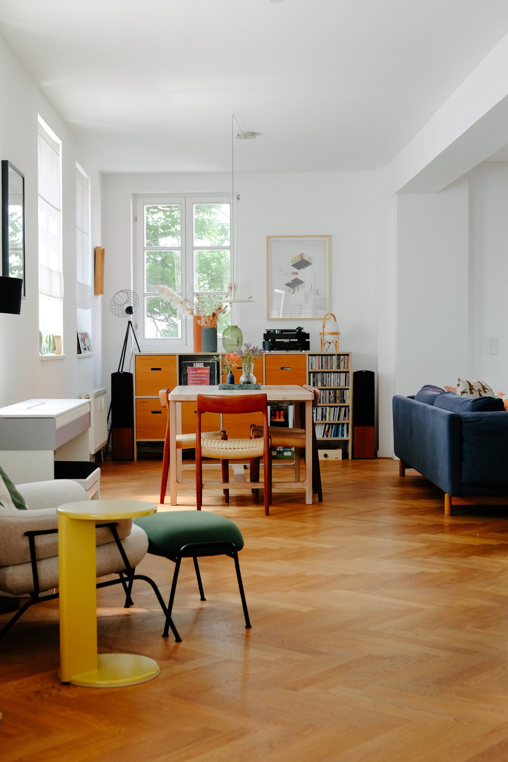 Wohnzimmer eines Familienhauses mit maßgefertigten Möbeln in angenehmen Farben, einschließlich Esstisch und Stühlen im skandinavischen Stil.