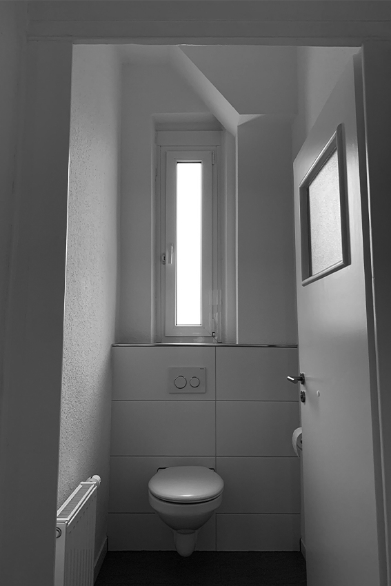 Badezimmer mit schlecht gewarteter Toilette und Tür in Nürnberg. 